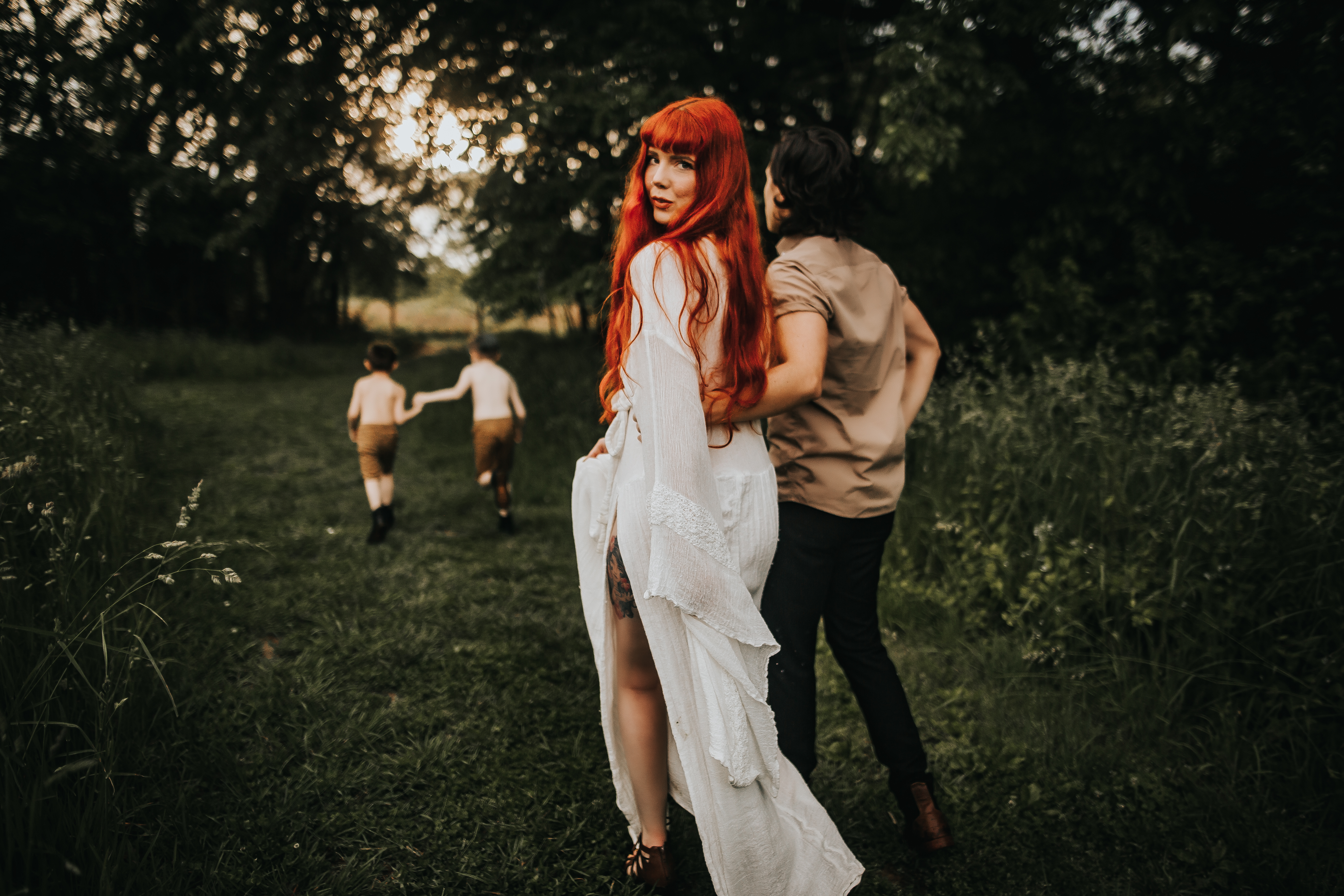a beautiful red haired mother with family in a green field