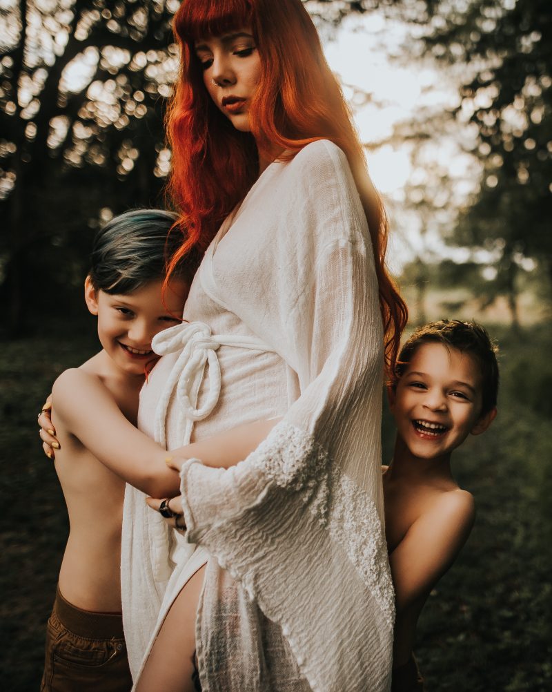 a beautiful red haired mother with family in a green field