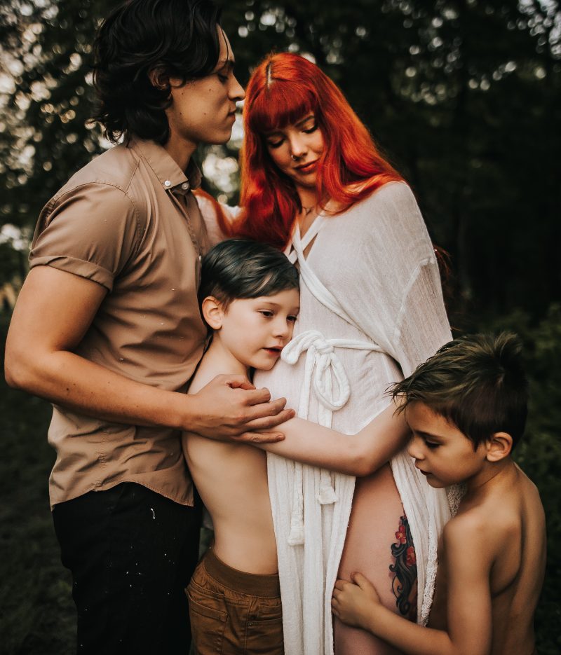 a beautiful red haired mother with family in a green field