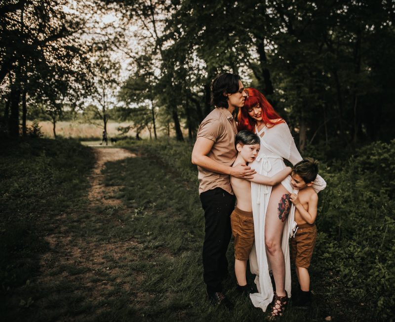 a beautiful red haired mother with family in a green field