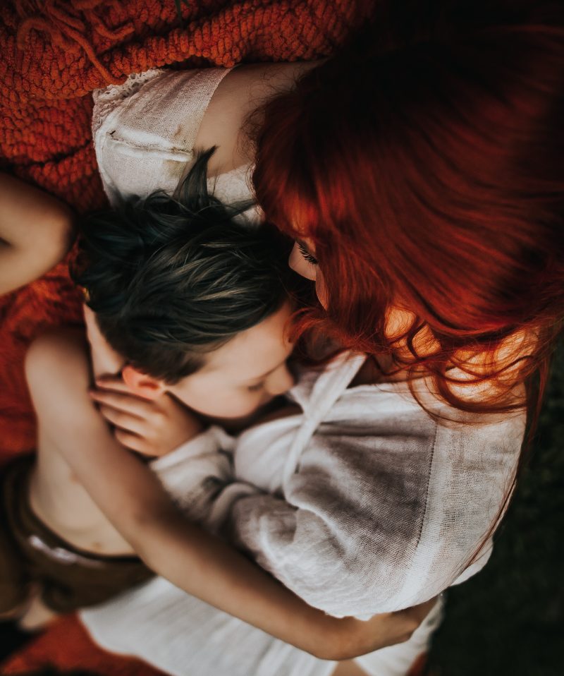 a beautiful red haired mother with family in a green field