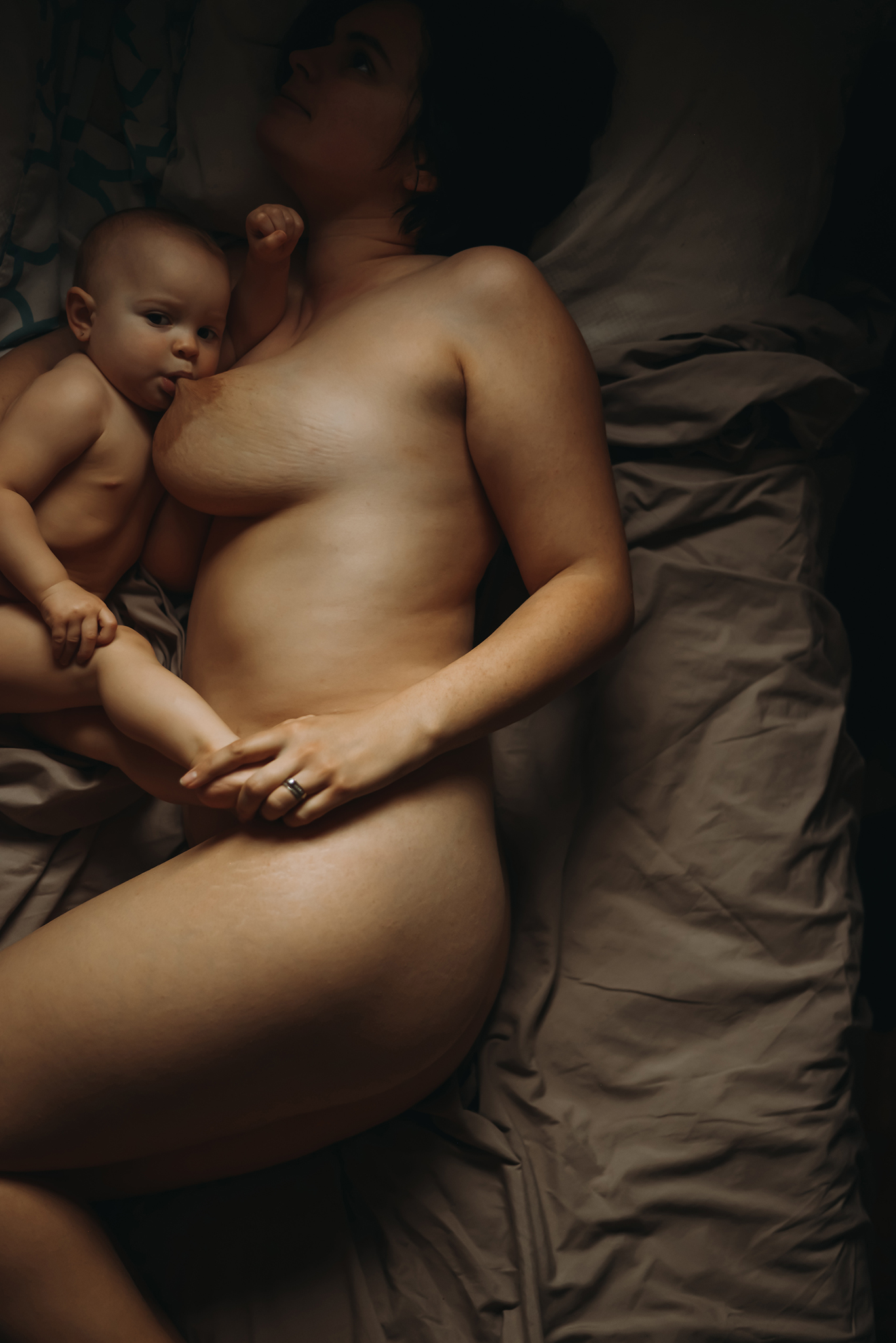 mother and baby breastfeeding in bed