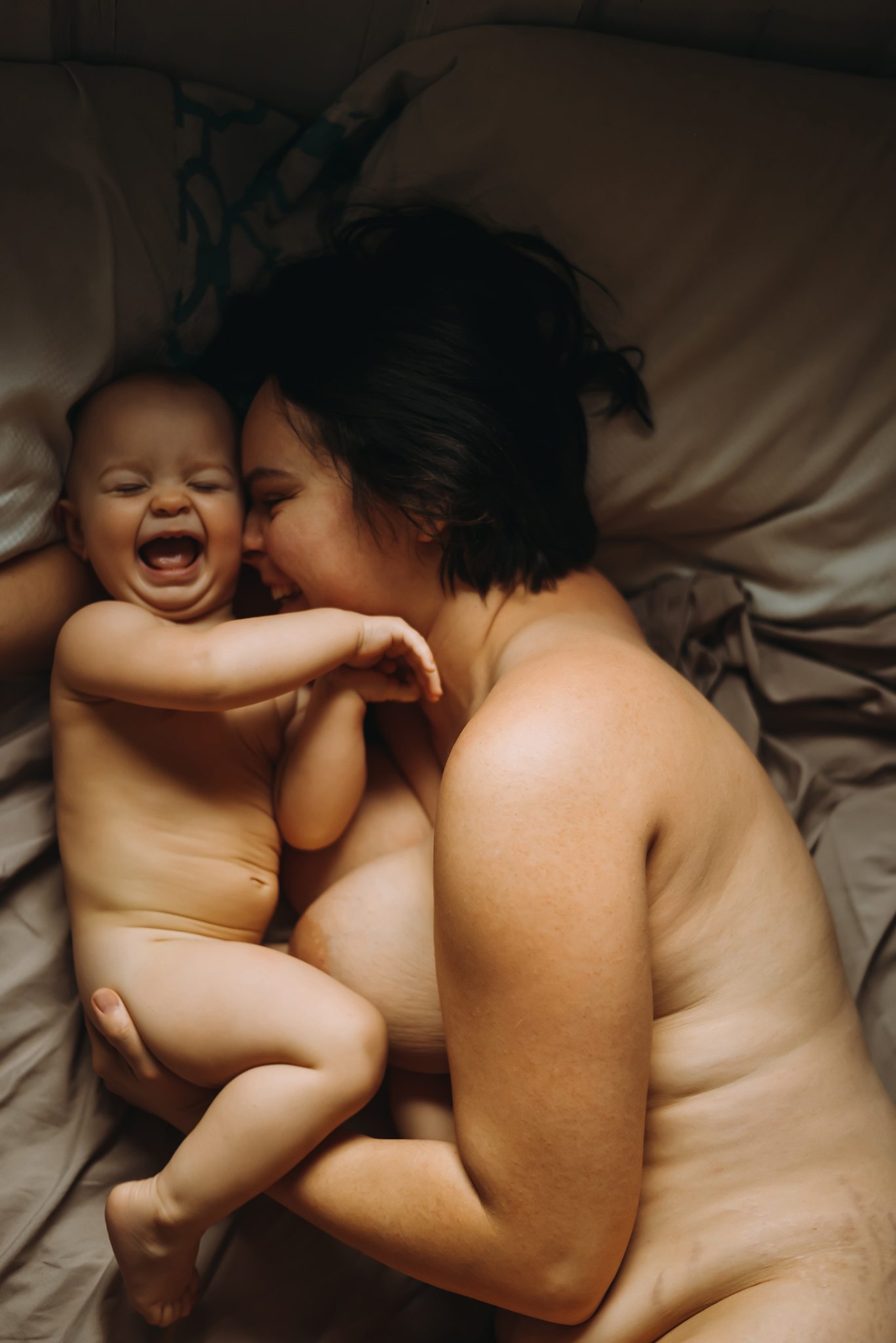 mother and baby breastfeeding in bed