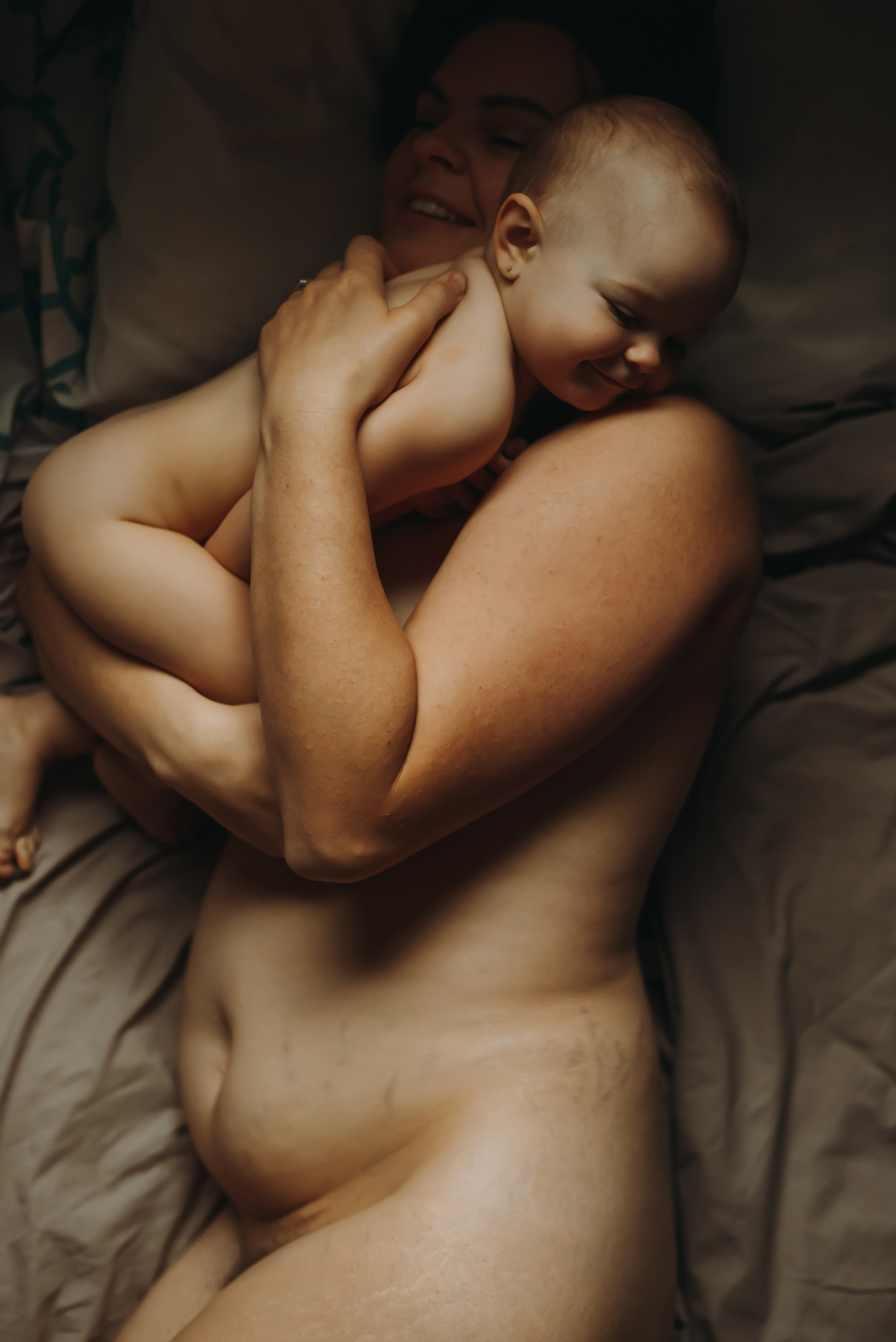 mother and baby breastfeeding in bed